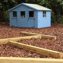 wooden play area and blue summerhouse